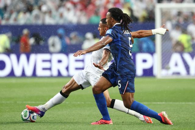 Iraq's forward #09 Ali Al-Hamadi (L) and France's defender #05 Jules Kounde fight for the ball during the 2026 World Cup Group I football match between France and Iraq at the Philadelphia Stadium in Philadelphia on June 22, 2026.  (Photo by FRANCK FIFE / AFP)