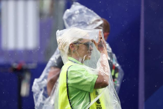 A staff worker wears a raincoat during the 2026 World Cup Group I football match between France and Iraq at the Philadelphia Stadium in Philadelphia on June 22, 2026.  (Photo by FRANCK FIFE / AFP)