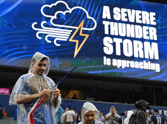 A French fan gestures past a screen showing a severe thunder storm warning during the 2026 World Cup Group I football match between France and Iraq at the Philadelphia Stadium in Philadelphia on June 22, 2026.  (Photo by ROBERTO SCHMIDT / AFP)