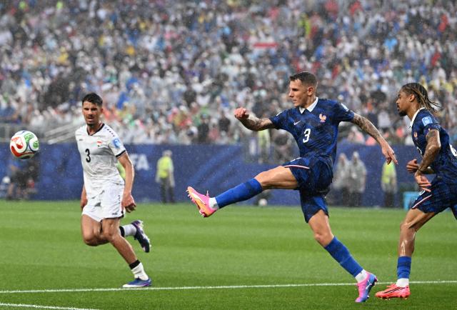 France's defender #03 Lucas Digne clears the ball past Iraq's defender #03 Hussein Ali during the 2026 World Cup Group I football match between France and Iraq at the Philadelphia Stadium in Philadelphia on June 22, 2026.  (Photo by ROBERTO SCHMIDT / AFP)