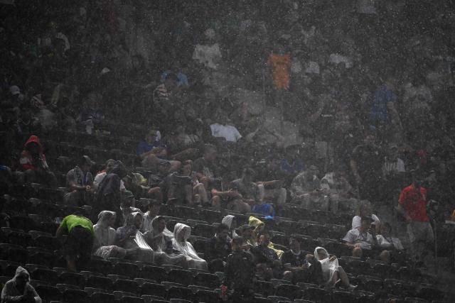 Fans wait in the rain at halftime during the 2026 World Cup Group I football match between France and Iraq at Philadelphia Stadium in Philadelphia on June 22, 2026.  (Photo by Mauro PIMENTEL / AFP)