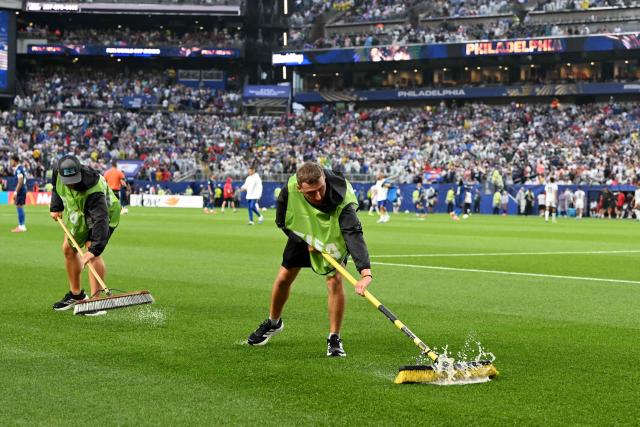 Staff workers drain the water from the field as the 2026 World Cup Group I football match between France and Iraq is suspended due to adverse weather at the Philadelphia Stadium in Philadelphia on June 22, 2026.  (Photo by ROBERTO SCHMIDT / AFP)