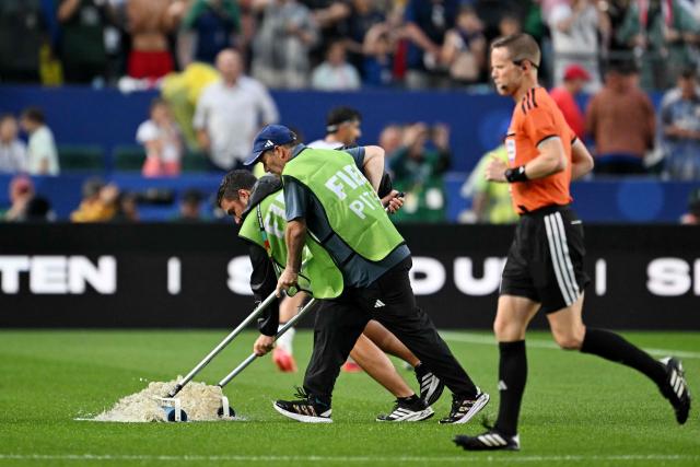 Staff workers drain the water from the field as the 2026 World Cup Group I football match between France and Iraq is suspended due to adverse weather at the Philadelphia Stadium in Philadelphia on June 22, 2026.  (Photo by ROBERTO SCHMIDT / AFP)
