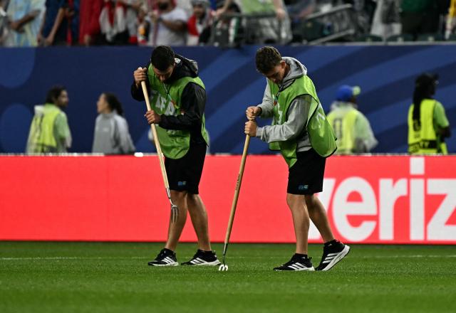 Staff workers drain the water from the field as the 2026 World Cup Group I football match between France and Iraq is suspended due to adverse weather at the Philadelphia Stadium in Philadelphia on June 22, 2026.  (Photo by Jewel SAMAD / AFP)