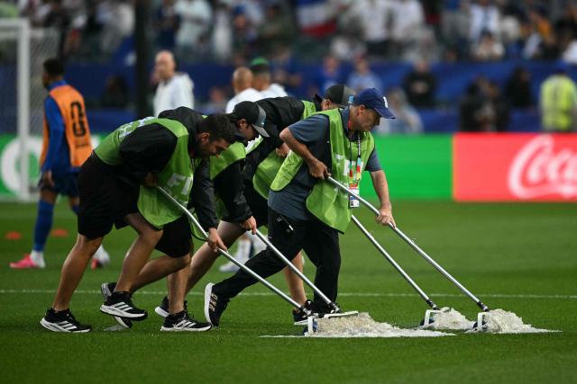 Staff workers drain the water from the field as the 2026 World Cup Group I football match between France and Iraq is suspended due to adverse weather at the Philadelphia Stadium in Philadelphia on June 22, 2026.  (Photo by MAURO PIMENTEL / AFP)