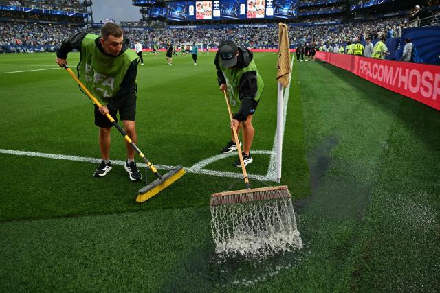 Staff workers drain the water from the field as the 2026 World Cup Group I football match between France and Iraq is suspended due to adverse weather at the Philadelphia Stadium in Philadelphia on June 22, 2026.  (Photo by MAURO PIMENTEL / AFP)