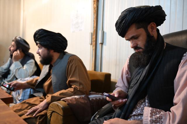 Taliban administrative staff use feature phones at the Department of Information and Culture building in Kandahar on June 22, 2026 following a ban imposed on smartphones for all government employees in Afghanistan. Government workers in different parts of Afghanistan have started switching off their smartphones, following an order imposed June 17, that they told AFP came from Supreme Leader Hibatullah Akhundzada. (Photo by Sanaullah SEIAM / AFP)