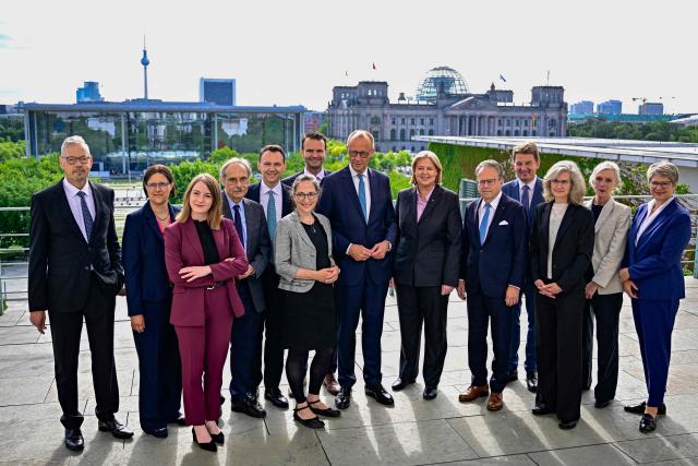 Germany's Chancellor Friedrich Merz (centre,L) poses for a picture with German Minister for Labour and Social Affairs Baerbel Bas(centre,R) and the rest of the 13-member pension reform commission after presenting the commissions recommendations at the chancellery in Berlin on June 23, 2026. (Photo by Tobias SCHWARZ / AFP)
