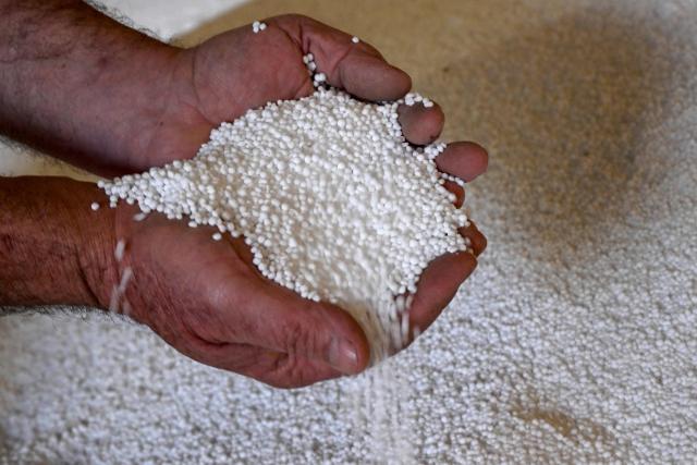 A photo taken on June 22, 2026 shows a farmer holding urea fertiliser at a fertiliser depot in the small rural town of Buffalo, some 163kms south-west of Melbourne. Importing 90 percent of fertilisers, Australia is facing a severe shortage due to the closure of the Strait of Hormuz. (Photo by William WEST / AFP)