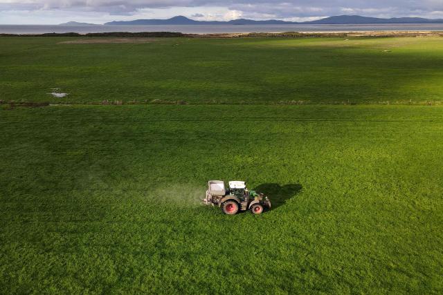 A photo taken on June 22, 2026 shows a tractor with a spreader fertilising paddocks on a dairy farm near the small rural town of Yanakie, some 190kms south-west of Melbourne. Importing 90 percent of fertilisers, Australia is facing a severe shortage due to the closure of the Strait of Hormuz. (Photo by William WEST / AFP)