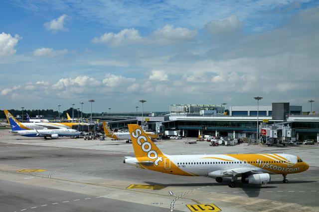 A Scoot Airbus A320 passenger aircraft (R) taxis on the tarmac at Singapore Changi Airport in Singapore on June 23, 2026. (Photo by Roslan RAHMAN / AFP)