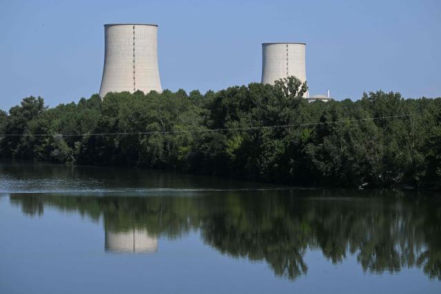 Tis photograph shows a view of the stopped Golfech nuclear power plant in southwestern France is pictured after its shutdown  on June 22 evening, due to "environmental constraints" related to an ongoing heatwave, on June 23, 2026 in Golfech. In periods of extreme heat, rising river temperatures can force EDF to reduce, or even halt, its production in order to avoid further warming the waterways. The operation of the plants is governed by maximum heating thresholds for bodies of water, which must not be exceeded, in order to protect wildlife and plant life. (Photo by Lionel BONAVENTURE / AFP)