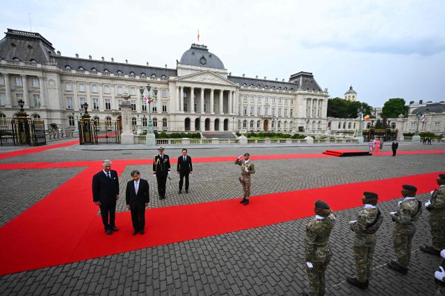 Japan's Emperor Naruhito (C), accompanied by King Philippe - Filip of Belgium - walks past soldiers during a welcoming ceremony at the Palaces square (Place des Palais) during his official state visit in Belgium , in Brussels on June 23, 2026. (Photo by ERIC LALMAND / Belga / AFP) / Belgium OUT