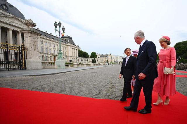 LtoR, Japan's Emperor Naruhito, accompanied by Queen Mathilde of Belgium (R) and King Philippe - Filip of Belgium -attends a welcoming ceremony at the Palaces square (Place des Palais) during an official state visit in Belgium, in Brussels on June 23, 2026. (Photo by ERIC LALMAND / Belga / AFP) / Belgium OUT