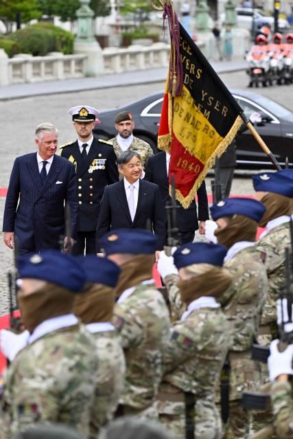 Japan's Emperor Naruhito (C), accompanied by King Philippe - Filip of Belgium - walks past soldiers during a welcoming ceremony at the Palaces square (Place des Palais) during his official state visit in Belgium , in Brussels on June 23, 2026. (Photo by ERIC LALMAND / Belga / AFP) / Belgium OUT