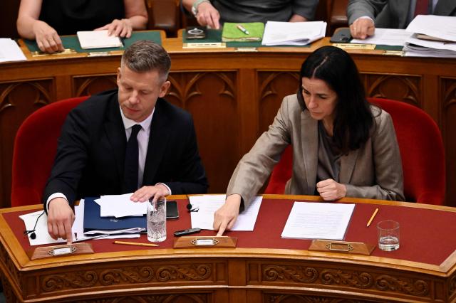 Hungarian Prime Minister Peter Magyar (L) and Foreign Minister Anita Orban (R) vote with other members of parliament in the main hall of the Parliament on June 23, 2026, during an extraordinary session of the National Assembly. Hungarian lawmakers on June 23 approved anti-corruption measures, part of new Prime Minister Peter Magyar's sweeping reform drive and aimed at helping the country get billions of euros in withheld European Union funds. The EU announced late last month it would unlock more than 16 billion euros (USD 18 billion) for Hungary that had been frozen over rule-of-law concerns during nationalist Viktor Orban's rule, if Budapest stays on track with a major reform push. (Photo by Attila KISBENEDEK / AFP)