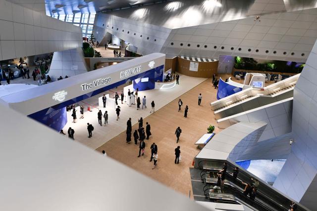 Attendees walk at the Dalian International Conference Centre during the World Economic Forum Annual Meeting of the New Champions in Dalian, China's Liaoning province on June 23, 2026. (Photo by WANG Zhao / AFP)