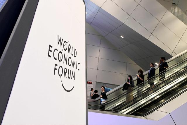 Attendees take the escalator at the Dalian International Conference Centre during the World Economic Forum Annual Meeting of the New Champions in Dalian, China's Liaoning province on June 23, 2026. (Photo by WANG Zhao / AFP)