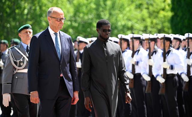 German Chancellor Friedrich Merz (2nd R) and Senegal's President Bassirou Diomaye Faye (R) review a military honor guard during a welcome ceremony at the Chancellery in Berlin on June 23, 2026. (Photo by Tobias SCHWARZ / AFP)
