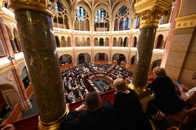 Visitors watch from a balcony as members of parliament vote in the main hall of the Parliament on June 23, 2026, during an extraordinary session of the National Assembly. Hungarian lawmakers on June 23 approved anti-corruption measures, part of new Prime Minister Peter Magyar's sweeping reform drive and aimed at helping the country get billions of euros in withheld European Union funds. The EU announced late last month it would unlock more than 16 billion euros (USD 18 billion) for Hungary that had been frozen over rule-of-law concerns during nationalist Viktor Orban's rule, if Budapest stays on track with a major reform push. (Photo by Attila KISBENEDEK / AFP)