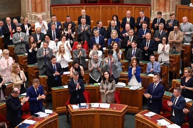 Hungarian Prime Minister Peter Magyar (front 3rdL), Foreign Minister Anita Orban (front 3rdR) and other members of parliament stand and applaud after voting for new legislation in the main hall of the Parliament on June 23, 2026, during an extraordinary session of the National Assembly. Hungarian lawmakers on June 23 approved anti-corruption measures, part of new Prime Minister Peter Magyar's sweeping reform drive and aimed at helping the country get billions of euros in withheld European Union funds. The EU announced late last month it would unlock more than 16 billion euros (USD 18 billion) for Hungary that had been frozen over rule-of-law concerns during nationalist Viktor Orban's rule, if Budapest stays on track with a major reform push. (Photo by Attila KISBENEDEK / AFP)