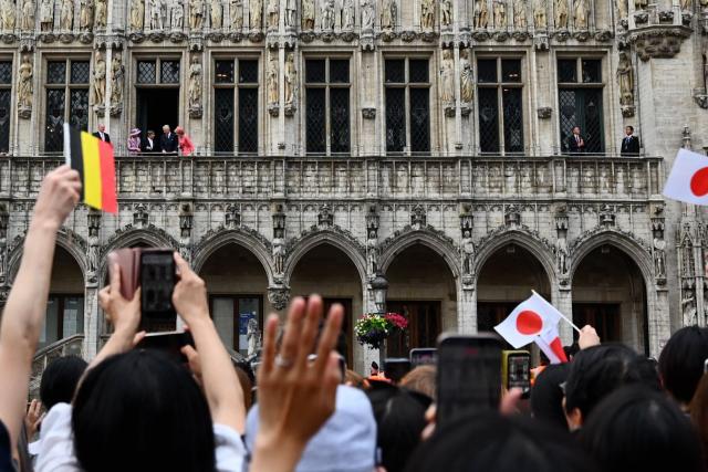 (LtoR) Japan's Empress Masako, Japan's Emperor Naruhito, King Philip - Filip of Belgium and Queen Mathilde of Belgium stand on a balcony as members of public greet them, as part of an official state visit in Belgium, at the City Hall in Brussels on June 23, 2026. (Photo by ERIC LALMAND / Belga / AFP) / Belgium OUT