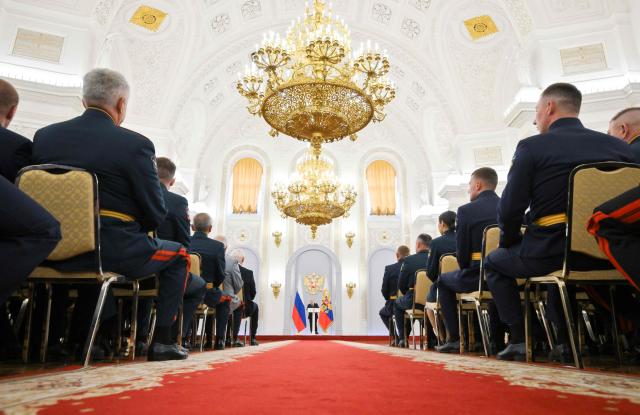 In this pool photograph distributed by the Russian state agency Sputnik, Russia's President Vladimir Putin gives a speech during a meeting with graduates of higher military educational institutions at the Kremlin in Moscow on June 23, 2026. (Photo by Yuri KOCHETKOV / POOL / AFP)