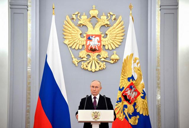 In this pool photograph distributed by the Russian state agency Sputnik, Russia's President Vladimir Putin gives a speech during a meeting with graduates of higher military educational institutions at the Kremlin in Moscow on June 23, 2026. (Photo by Yuri KOCHETKOV / POOL / AFP)