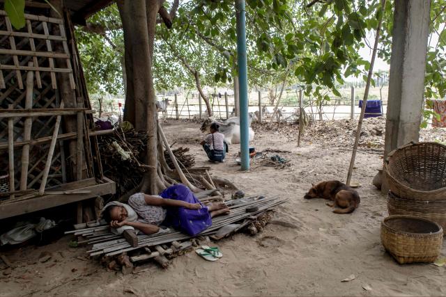This photo taken on June 21, 2026 shows a woman, displaced by fighting between Myanmar's military and the People's Defence Forces (PDF) in Myit Chay, sleeping by a shelter near Pakokku in Myanmar's Magway region. (Photo by AFP)