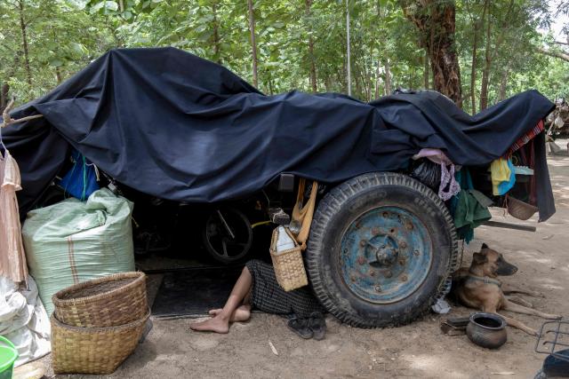 This photo taken on June 21, 2026 shows a man, displaced by fighting between Myanmar's military and the People's Defence Forces (PDF) in Myit Chay, sleeping under a makeshift shelter near Pakokku in Myanmar's Magway region. (Photo by AFP)