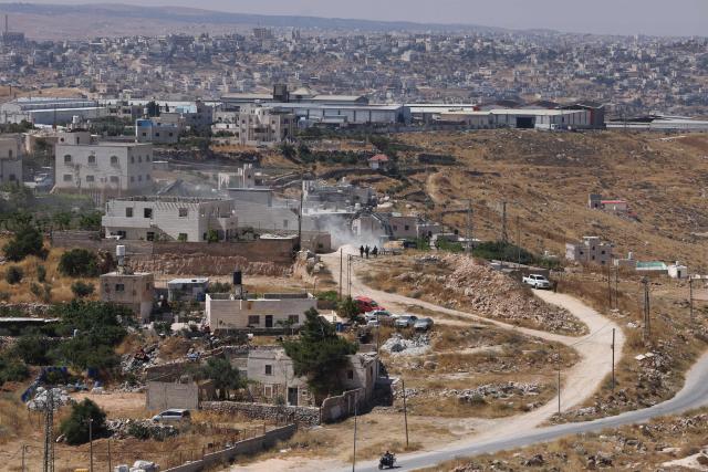 Israeli bulldozers guarded by Israeli soldiers demolish the home belonging to the Palestinian al-Atrash family, citing the lack of a building permit, in the village of Qilqes, a few kilometres from the Israeli settlement of Beit Hagai, just south of the Israeli-occupied West Bank city of Hebron on June 23, 2026. Excluding east Jerusalem, which was occupied and annexed by Israel in 1967, some 500,000 Israeli settlers live in the West Bank, along with about three million Palestinian residents. (Photo by HAZEM BADER / AFP) / 