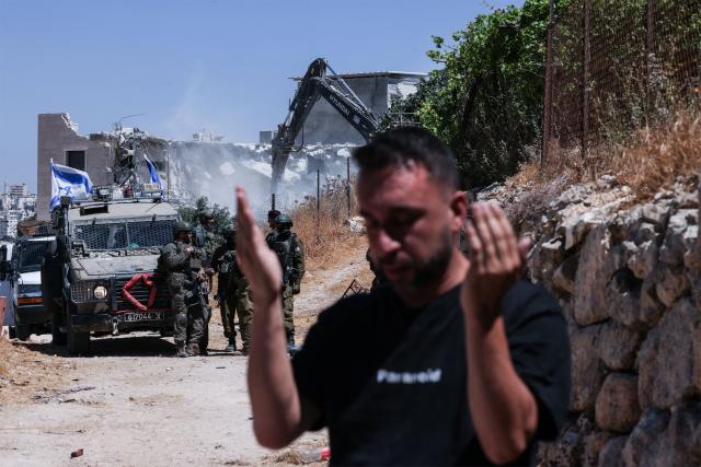 Palestinian Saud al-Atrash prays, as Israeli security forces demolish the family home and shops citing the lack of a building permit in the village of Qilqes, a few kilometres from the Israeli settlement of Beit Hagai, just south of the Israeli-occupied West Bank city of Hebron on June 23, 2026. Excluding east Jerusalem, which was occupied and annexed by Israel in 1967, some 500,000 Israeli settlers live in the West Bank, along with about three million Palestinian residents. (Photo by HAZEM BADER / AFP)