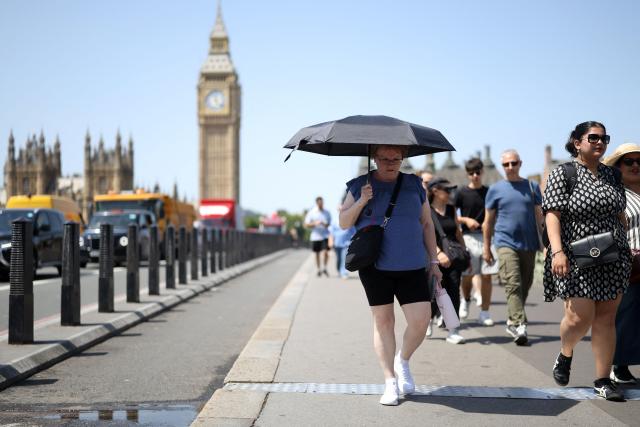 A person uses an umbrella to shelter from the direct sun, on a hot summer's day,in London on June 23, 2026. (Photo by Toby Shepheard / AFP)