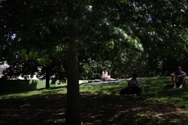 A person uses an umbrella to shelter from the direct sun, on a hot summer's day,in London on June 23, 2026. (Photo by Toby Shepheard / AFP)