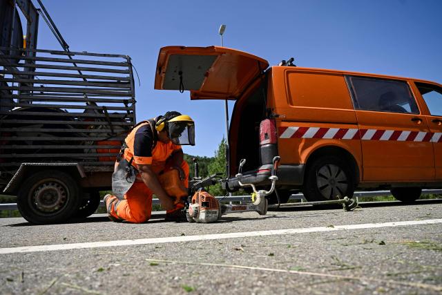 A worker prepares to cut the grass on the side of the road in the Sobrarbe region, Huesca province, on June 23, 2026. Nearly all of Spain was under a heat alert on June 23, with parts of the south and north of the country placed on the highest warning level as a heatwave grips most of western Europe. Temperatures of up to 40C in the shade were forecast in parts of the Basque Country on the border with France, an area where such extreme heat is relatively uncommon. (Photo by ANDER GILLENEA / AFP)
