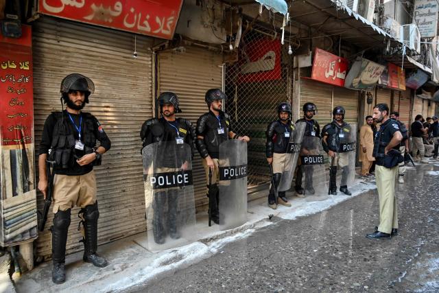Security personnel stand guard during a religious procession on the seventh day of Ashura in the Islamic holy month of Muharram in Peshawar on June 23, 2026. (Photo by Abdul MAJEED / AFP)
