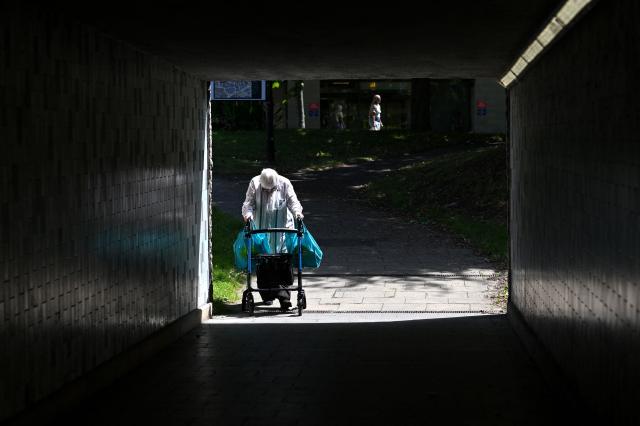 A person using a mobility walker enters an underpass in Huddersfield in northern England on June 23, 2026. Multiple schools in England shut early on June 23 and set to remain closed for two more days with a heatwave expected to set new records in the UK as it spreads across Europe. (Photo by Oli SCARFF / AFP)
