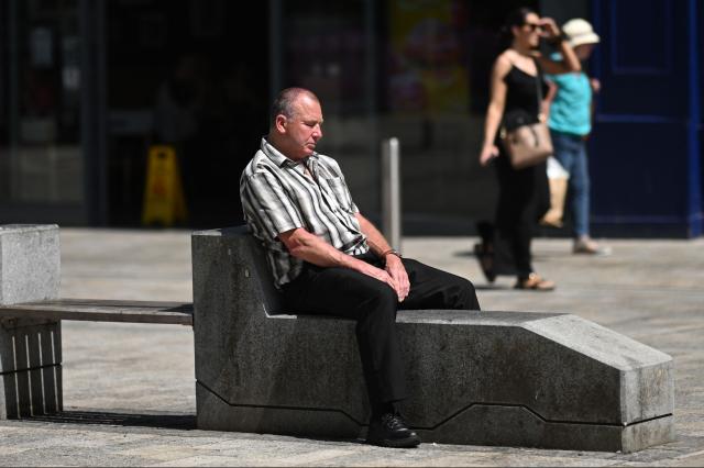 A person sunbathes in Huddersfield in northern England on June 23, 2026. Multiple schools in England shut early on June 23 and set to remain closed for two more days with a heatwave expected to set new records in the UK as it spreads across Europe. (Photo by Oli SCARFF / AFP)