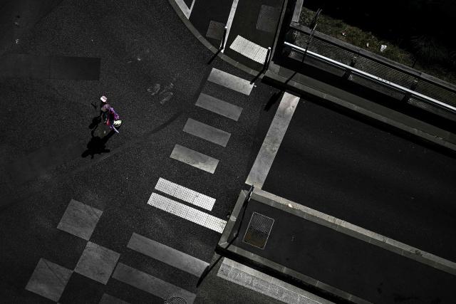 A pedestrian and a child wear caps to protect themselves from the sun as they cross a road in Bordeaux, southwestern France on June 23, 2026, as France experiences a heatwave. (Photo by Christophe ARCHAMBAULT / AFP)