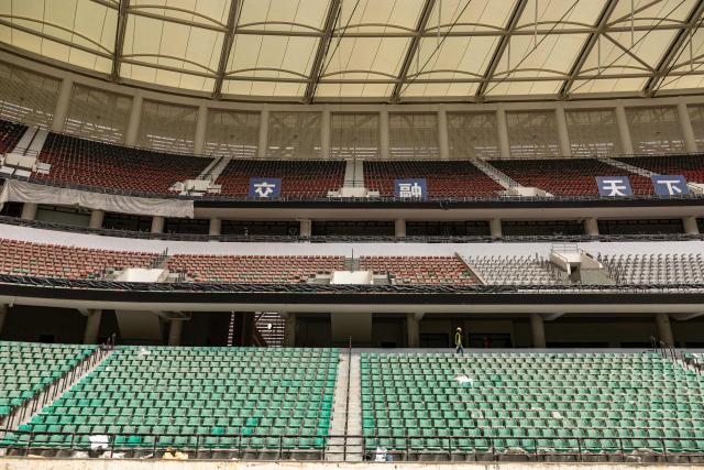 A construction worker walks past newly installed seats during a break at the Raila Odinga International Stadium, also known as Talanta Sports Stadium, a 60,000-seat national stadium under construction in Nairobi on June 23, 2026, ahead the Africa Cup of Nations (AFCON) scheduled for 2027. (Photo by SIMON MAINA / AFP)