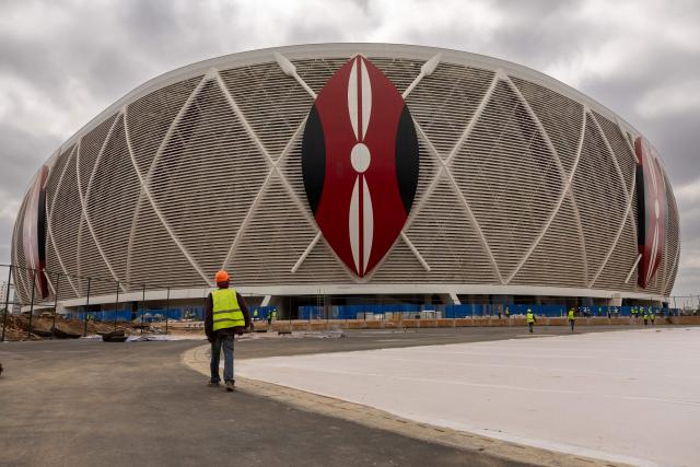 Construction workers walk during a break at the Raila Odinga International Stadium, also known as Talanta Sports Stadium, a 60,000-seat national stadium under construction in Nairobi on June 23, 2026, ahead the Africa Cup of Nations (AFCON) scheduled for 2027. (Photo by SIMON MAINA / AFP)