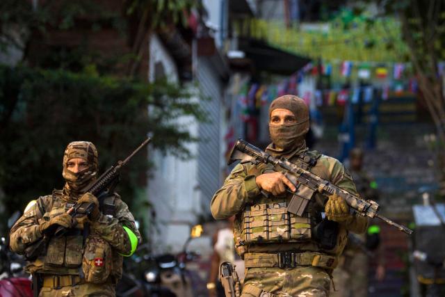 Brazilian Special Police forces patrol a street during the Operation Containment at the Santa Marta favela, in Rio de Janeiro, Brazil, on June 23, 2026. The operation targets alleged members linked to the Comando Vermelho drug trafficking organization as authorities seek to contain the gang's territorial expansion and dismantle its criminal infrastructure. (Photo by Daniel RAMALHO / AFP)