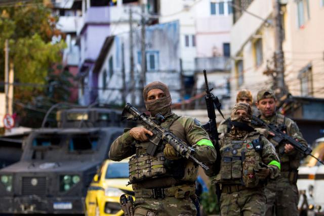 Brazilian Special Police forces patrol a street during the Operation Containment at the Santa Marta favela, in Rio de Janeiro, Brazil, on June 23, 2026. The operation targets alleged members linked to the Comando Vermelho drug trafficking organization as authorities seek to contain the gang's territorial expansion and dismantle its criminal infrastructure. (Photo by Daniel RAMALHO / AFP)