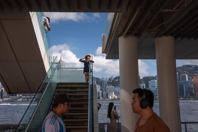 Tourists from mainland China visit a promenade along Victoria Harbour in Hong Kong on June 22, 2026. (Photo by Dale DE LA REY / AFP)