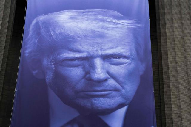 A banner featuring US President Donald Trump hangs on the outside of the Department of Justice headquarters ahead of a press conference with Acting Attorney General Todd Blanche announcing annual healthcare fraud takedown results in Washington, DC on June 23, 2026. (Photo by Ken Cedeno / AFP)