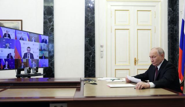In this pool photograph distributed by the Russian state agency Sputnik, Russia's President Vladimir Putin chairs a meeting with members of the government via videoconference in Moscow on June 23, 2026. (Photo by Gavriil Grigorov / POOL / AFP)