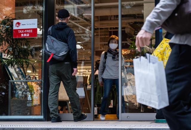 People enter an outdoor store with a tax free for tourists sign displayed on its facade in Tokyo on June 23, 2026, as the weak yen continues to draw foreign shoppers. The Tokyo stock market took a beating, shedding 3.6 percent, with investors keeping an eye on the yen as it came close to a 40-year low against the dollar, making exports including oil more expensive for Japan. (Photo by ANDREW CABALLERO-REYNOLDS / AFP)