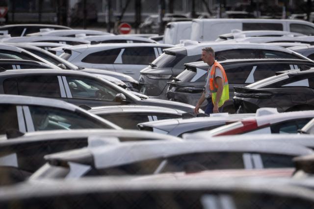 (FILES) A Stellantis employee walks in a car storage lot at the Stellantis automotive manufacturer factory in Sausheim, near Mulhouse, eastern France, on June 2, 2026. The CGT union at the Stellantis plant in Mulhouse has filed a strike notice from June 23 to June 28, 2026, to protest the working conditions of employees suffering from the extreme heat. (Photo by SEBASTIEN BOZON / AFP)