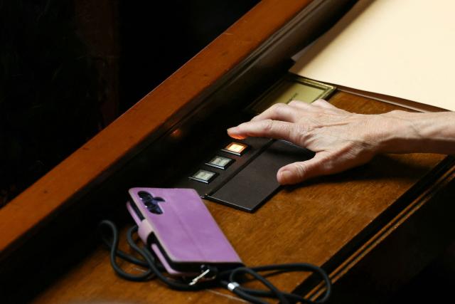 A Member of Parliament takes part in a formal vote on the draft constitutional reform bill that would grant unprecedented “autonomy” to Corsica, at The National Assembly, France's lower house of parliament in Paris on June 23, 2026. The French National Assembly has approved the principle of granting Corsica a form of “autonomy. (Photo by Alain JOCARD / AFP)