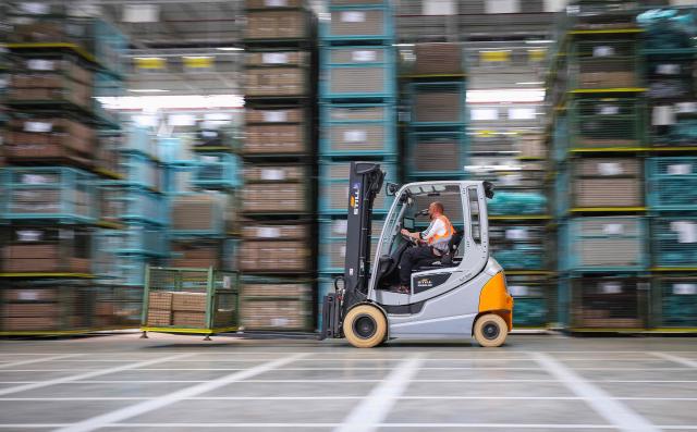 An employee drives a forklift through a warehouse of the new Daimler Truck Global Parts Center (GPC) in Halberstadt, eastern Germany, on June 23, 2026. Following its opening in 2025, the company has brought the logistics center fully online and now ships to 170 countries worldwide. (Photo by Ronny HARTMANN / AFP)